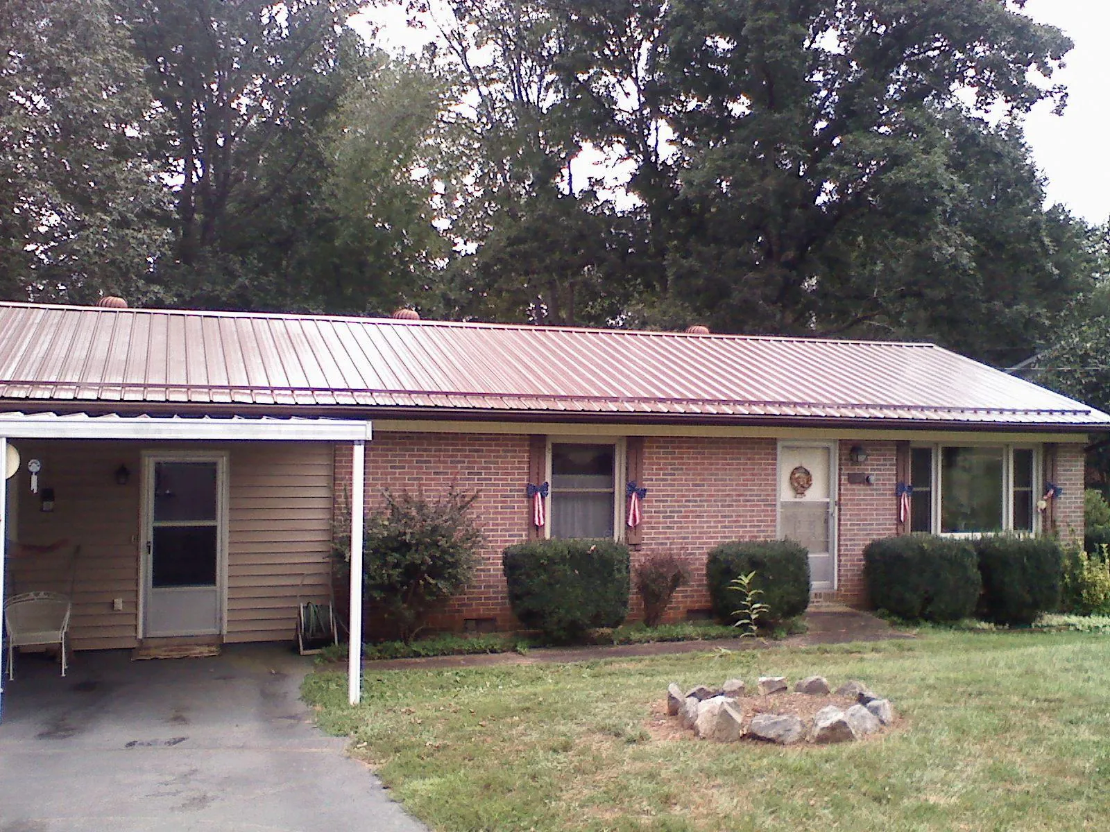 Bronze metal roof and carport on a brick ranch home — Roof Repair work by our crew in Lincolnton